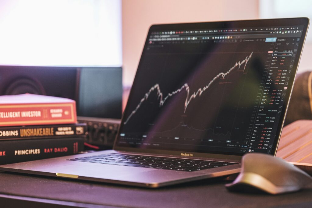 Aktien kaufen für Anfänger: Ein Laptop mit einem Candlestick-Chart im Aufwärtstrend